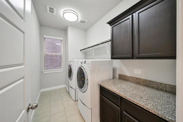 18323 Parkview Point Dr, Houston, TX 77094 - laundry area featuring independent washer and dryer, cabinet space, light tile patterned flooring, and baseboards