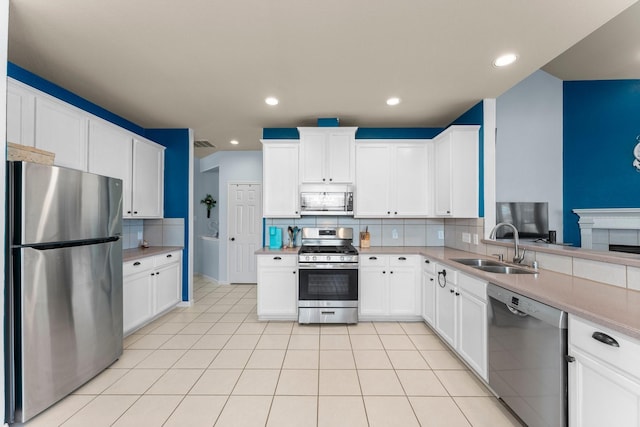 kitchen with stainless steel appliances, a sink, backsplash, light tile patterned floors, and recessed lighting
