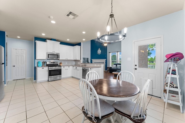 dining space featuring light tile patterned flooring and recessed lighting