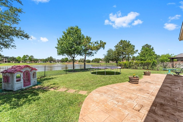 view of yard with a water view, a patio area, and a trampoline