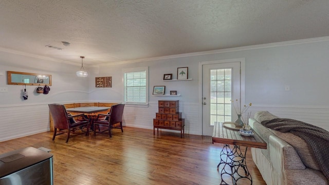 129 County Road 2063, Hull, TX 77564 - dining room with a textured ceiling, ornamental molding, wainscoting, and wood finished floors