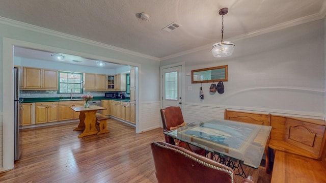 129 County Road 2063, Hull, TX 77564 - dining space featuring wainscoting, ornamental molding, and wood finished floors