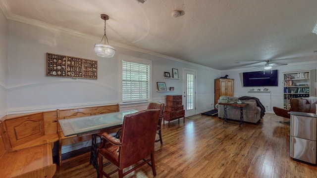 129 County Road 2063, Hull, TX 77564 - dining space featuring crown molding, wood finished floors, a ceiling fan, a textured ceiling, and a wainscoted wall