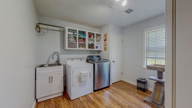 129 County Road 2063, Hull, TX 77564 - laundry room featuring cabinet space, washer and clothes dryer, light wood finished floors, and baseboards