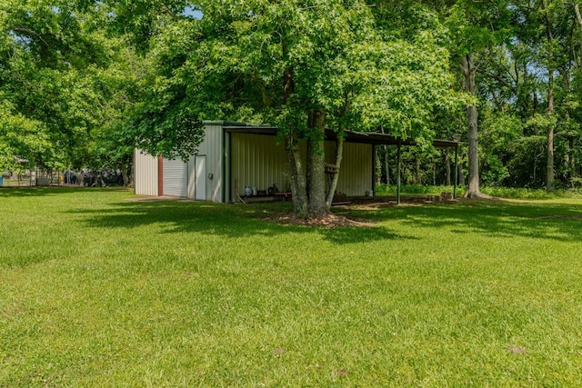 129 County Road 2063, Hull, TX 77564 - view of green lawn featuring an outbuilding, a detached garage, and a pole building