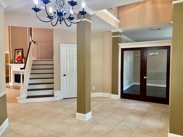 stairway with tile patterned flooring, a chandelier, and french doors