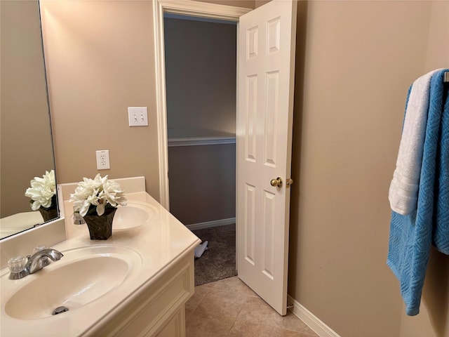 bathroom with tile patterned floors, double vanity, and baseboards