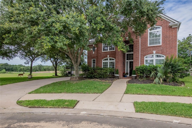 view of front of property featuring brick siding and a front yard