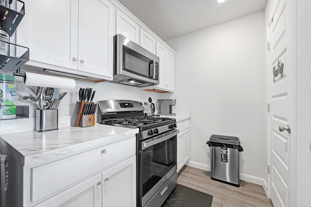 1325 Rd 5102, Cleveland, TX 77327 - kitchen featuring appliances with stainless steel finishes, light wood finished floors, white cabinetry, baseboards, and recessed lighting