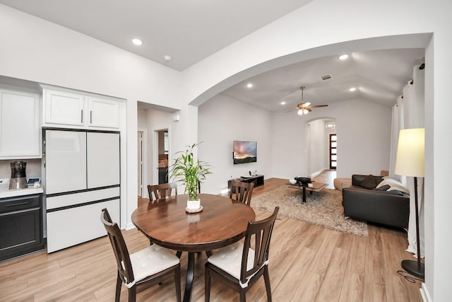 dining area featuring arched walkways, light wood-style flooring, ceiling fan, vaulted ceiling, and recessed lighting