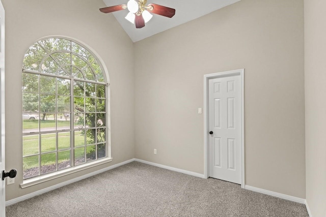 spare room featuring carpet, a ceiling fan, lofted ceiling, and baseboards