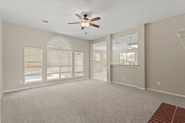 empty room with a ceiling fan, carpet, and baseboards