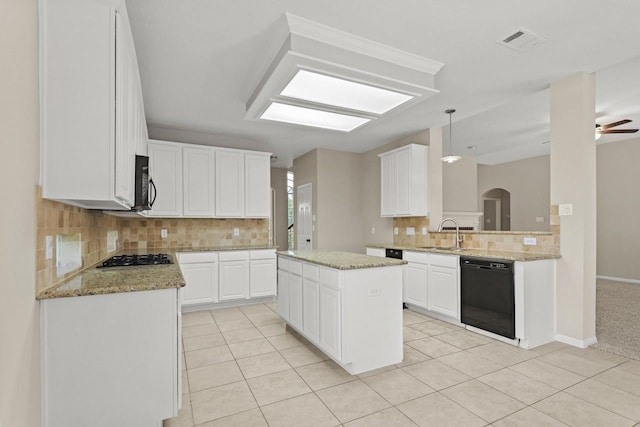 kitchen with black appliances, tasteful backsplash, a sink, and light tile patterned floors