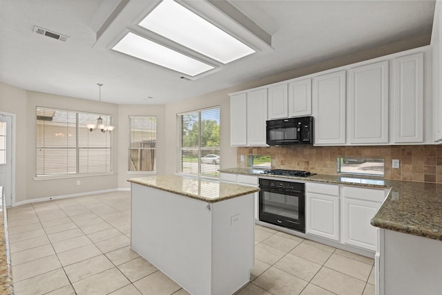 kitchen with black appliances, light tile patterned floors, a chandelier, a kitchen island, and decorative backsplash
