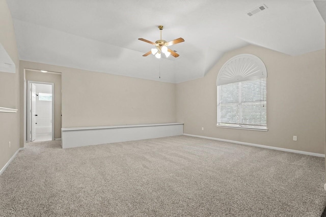 carpeted spare room featuring vaulted ceiling, a ceiling fan, and baseboards