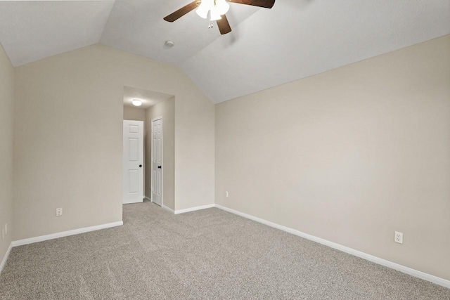 carpeted empty room with ceiling fan, lofted ceiling, and baseboards