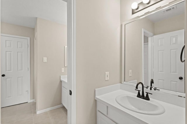 bathroom featuring vanity, tile patterned floors, and baseboards