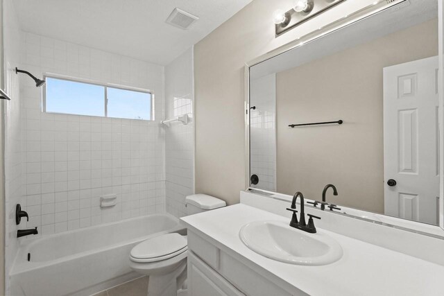 bathroom featuring toilet, shower / bathtub combination, and vanity