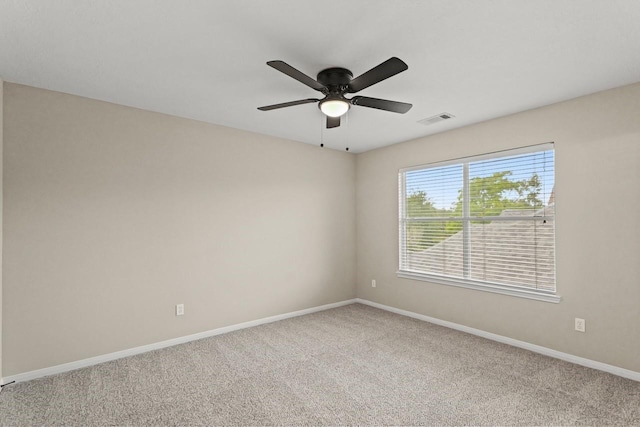 carpeted spare room with baseboards and a ceiling fan