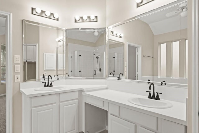 full bath featuring a stall shower, double vanity, and vaulted ceiling