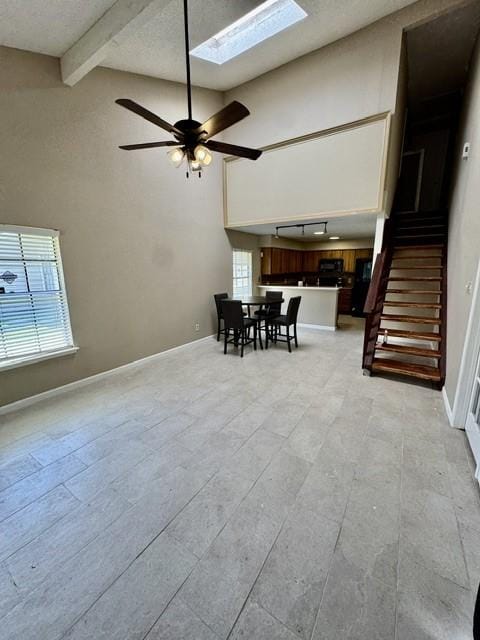 11957 Bob White Dr Unit 863, Houston, TX 77035 - dining room with a skylight, beamed ceiling, stairway, baseboards, and high vaulted ceiling
