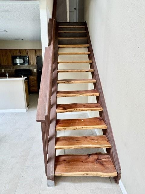 11957 Bob White Dr Unit 863, Houston, TX 77035 - stairway with a textured ceiling and baseboards