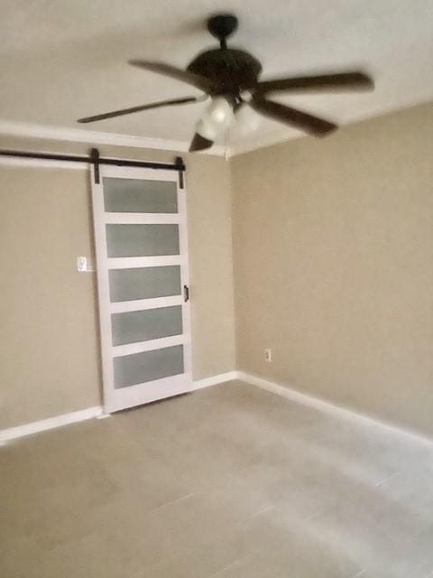 11957 Bob White Dr Unit 863, Houston, TX 77035 - spare room with a barn door, ceiling fan, and baseboards