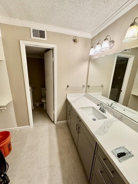 11957 Bob White Dr Unit 863, Houston, TX 77035 - bathroom featuring a textured ceiling, toilet, crown molding, vanity, and tile patterned flooring