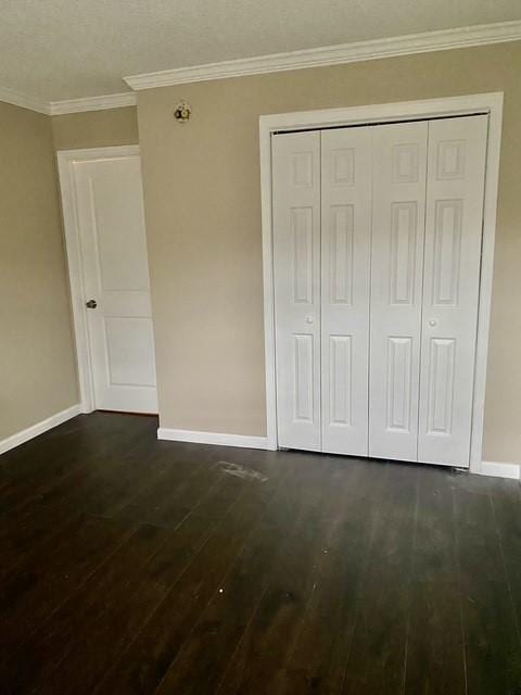 11957 Bob White Dr Unit 863, Houston, TX 77035 - unfurnished bedroom featuring baseboards, dark wood-style flooring, a closet, and crown molding