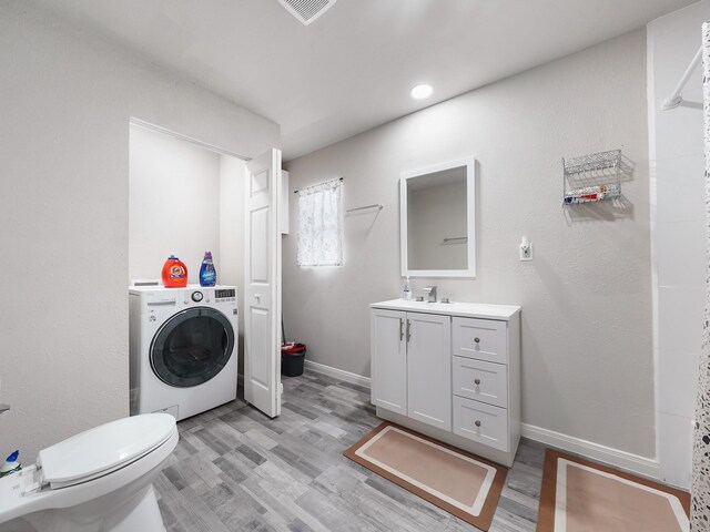 29 County Road 2131 Unit A, Cleveland, TX 77327 - bathroom featuring washer / clothes dryer, wood finished floors, toilet, and vanity
