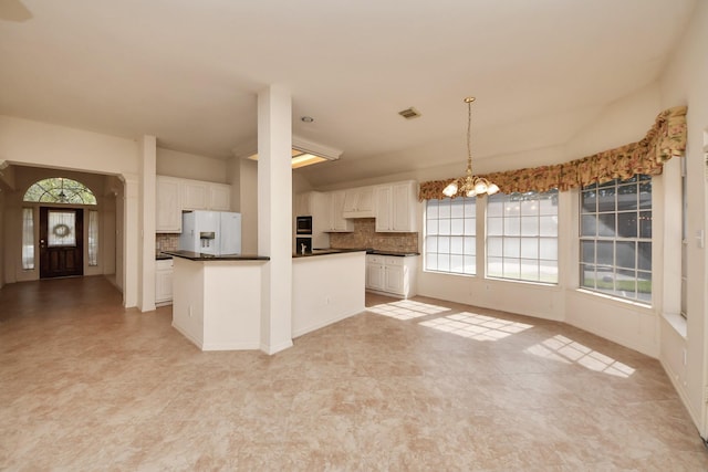 1119 Summer Brk, Sugar Land, TX 77479 - kitchen with white fridge with ice dispenser, dark countertops, decorative backsplash, and a chandelier