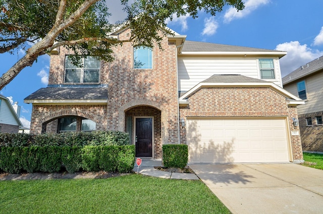 view of front of home featuring concrete driveway, brick siding, and a front yard