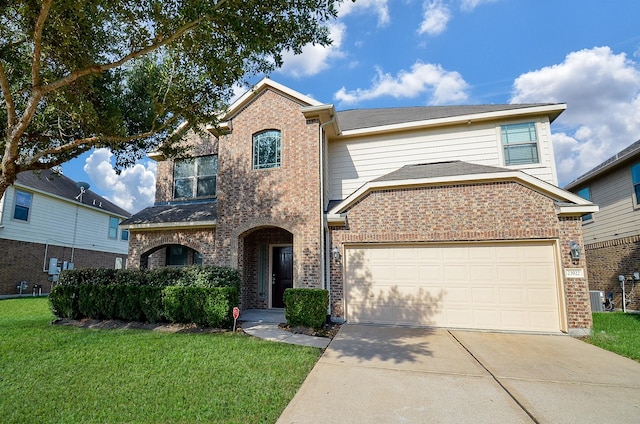 traditional-style home with brick siding, driveway, a front lawn, a garage, and central air condition unit
