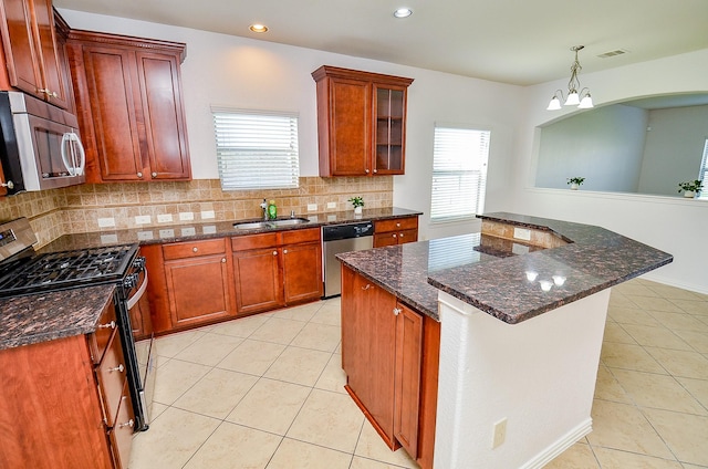 kitchen with appliances with stainless steel finishes, a sink, light tile patterned flooring, tasteful backsplash, and recessed lighting