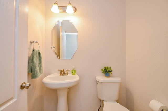 half bathroom featuring toilet and a sink