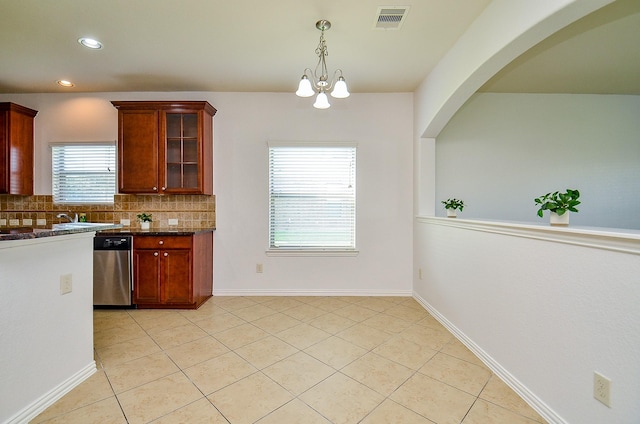 kitchen featuring stainless steel dishwasher, light tile patterned flooring, tasteful backsplash, glass insert cabinets, and a chandelier