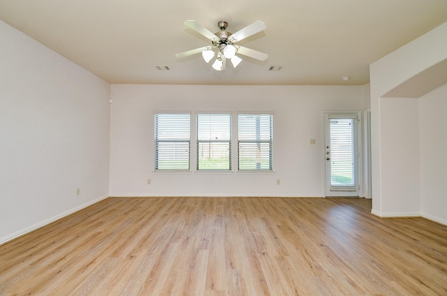 spare room featuring light wood-style floors, baseboards, and ceiling fan