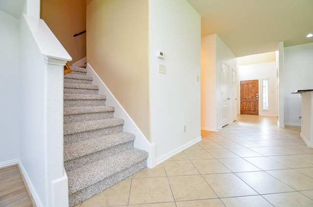 staircase featuring tile patterned floors and baseboards