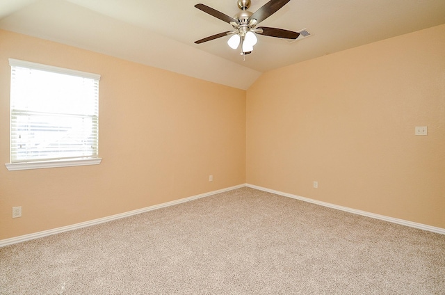 empty room with ceiling fan, carpet flooring, baseboards, and vaulted ceiling