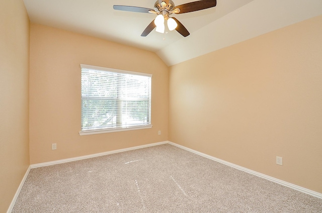 spare room featuring carpet floors, ceiling fan, baseboards, and lofted ceiling