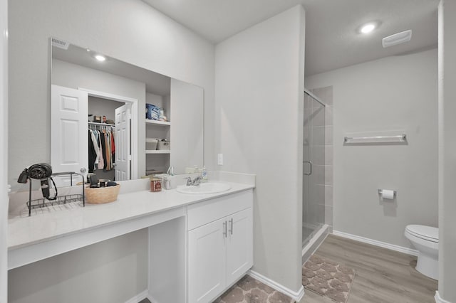 8230 Red Spruce St, Magnolia, TX 77354 - full bathroom with a shower stall, toilet, vanity, a walk in closet, and wood finished floors