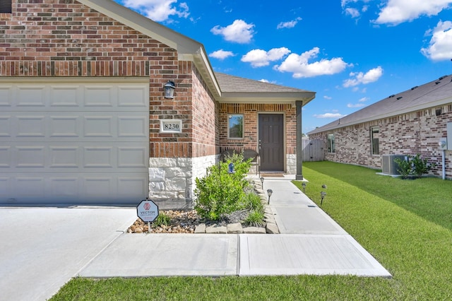 8230 Red Spruce St, Magnolia, TX 77354 - property entrance featuring brick siding, a lawn, stone siding, driveway, and an attached garage