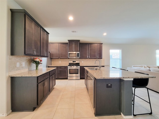 4931 Marina Shores Ct, Katy, TX 77493 - kitchen featuring stainless steel appliances, a sink, backsplash, dark brown cabinetry, and recessed lighting