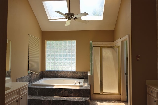 full bathroom featuring a skylight, vanity, a stall shower, a garden tub, and high vaulted ceiling
