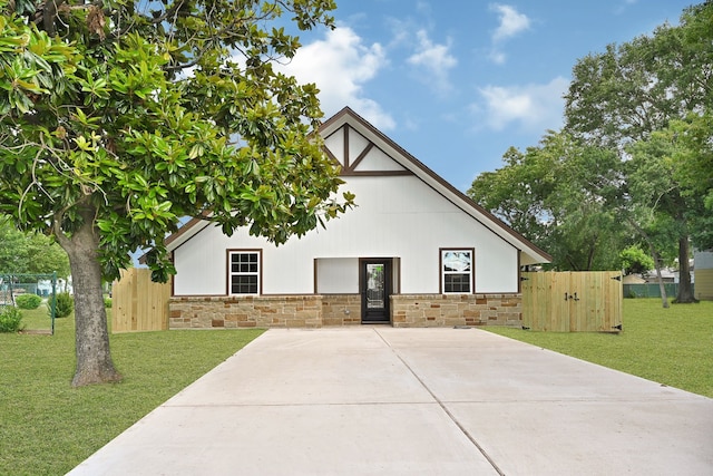 view of side of property with stone siding and a gate