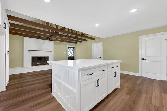 kitchen featuring dark wood-type flooring, white cabinetry, a center island, baseboards, and recessed lighting