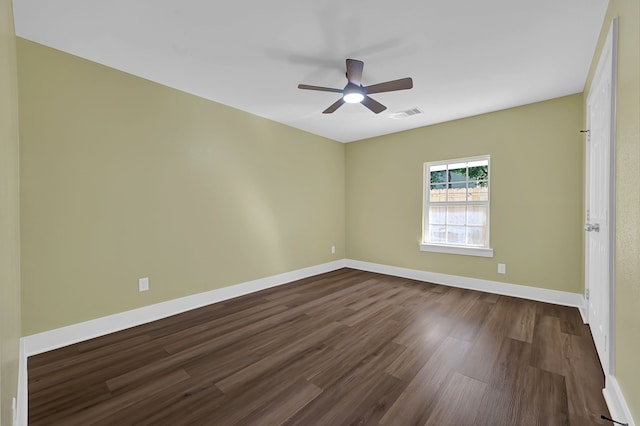 spare room with dark wood-style floors, ceiling fan, and baseboards