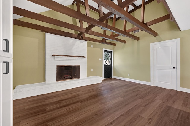 unfurnished living room featuring beamed ceiling, dark wood finished floors, baseboards, high vaulted ceiling, and a brick fireplace