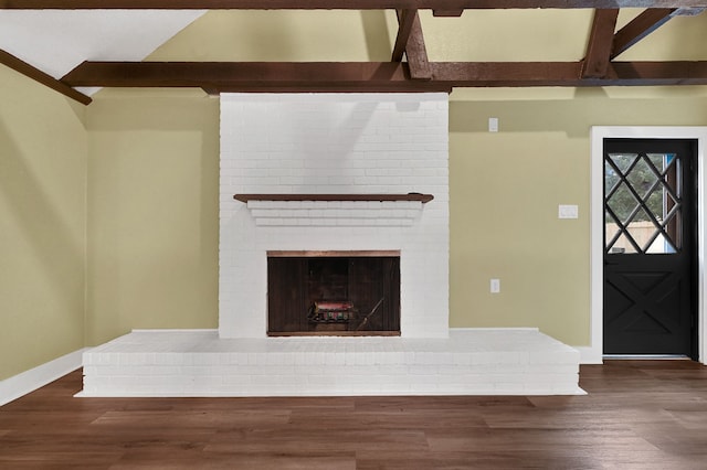 unfurnished living room featuring dark wood-style flooring, baseboards, and a brick fireplace