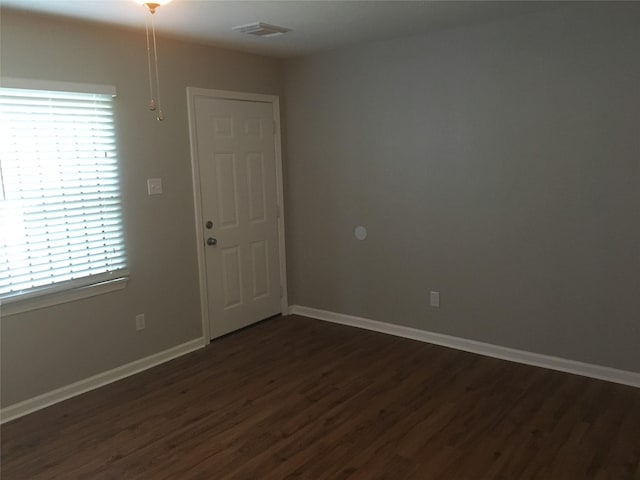empty room featuring dark wood-style flooring and baseboards